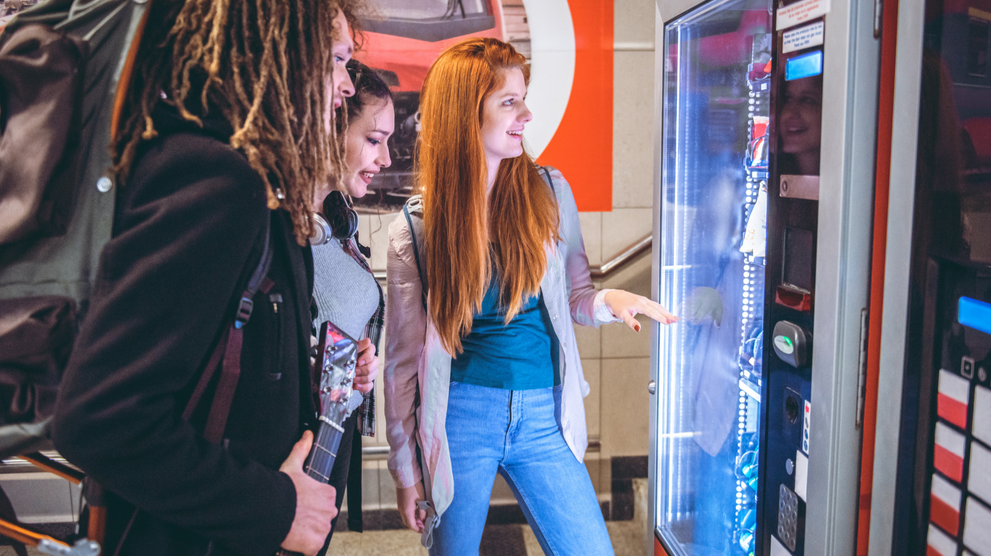 People selecting products from a vending machine