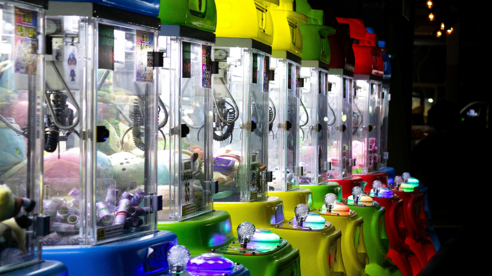 Row of claw machines filled with plush prizes