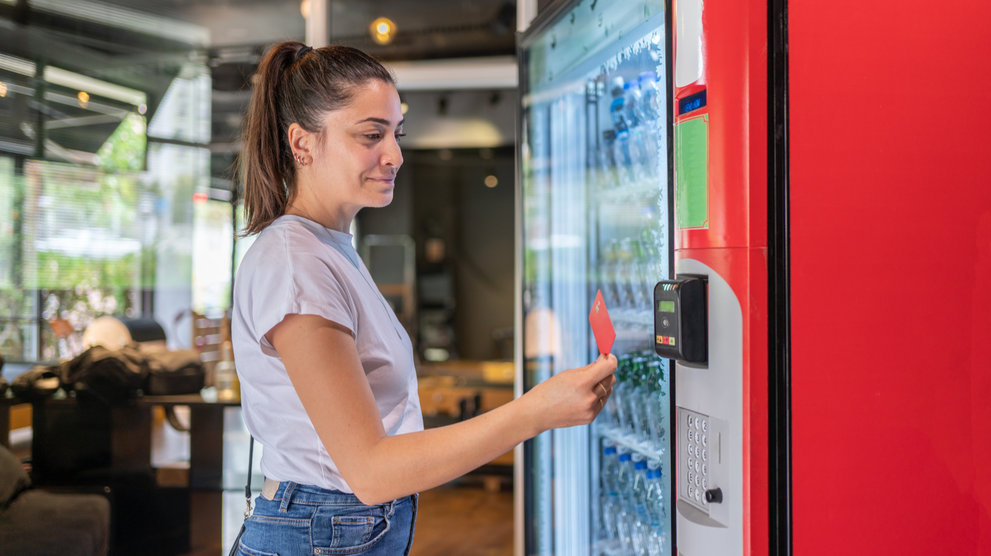 Woman using a card reader on a vending machine