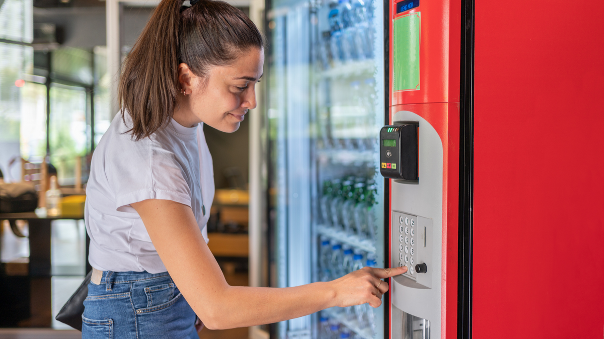 Woman using a vending machine payment system